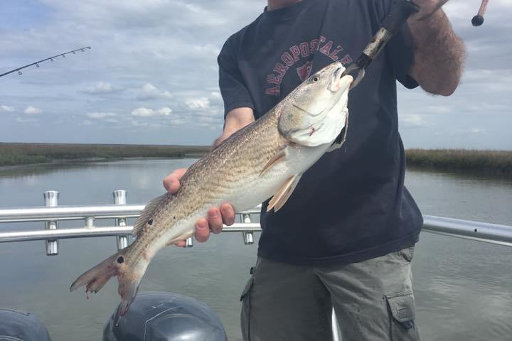 Man holding up large river fish caught on fishing trip