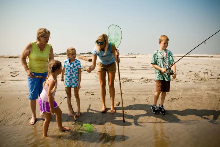 Tour guide talking to children on the beach