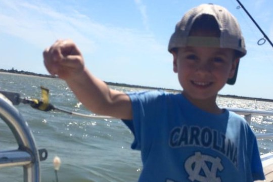 Little boy smiling at camera on a boat