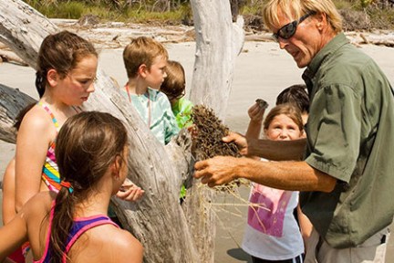 Tour guide showing school group ecology of the island