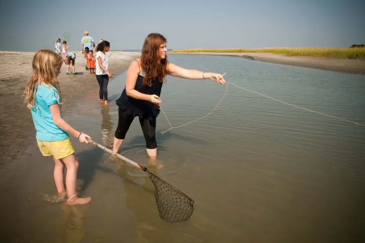 Group using cast nets to fish in island river