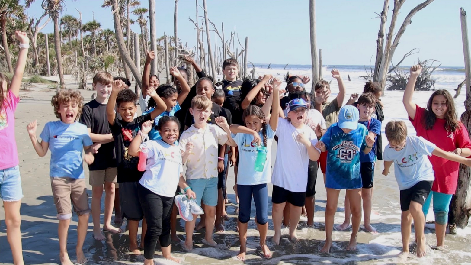 a group of people on a beach posing for the camera