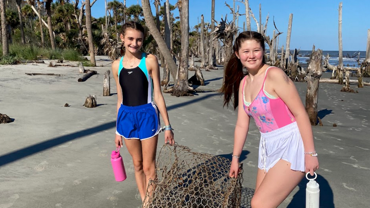 a group of people standing on a beach posing for the camera