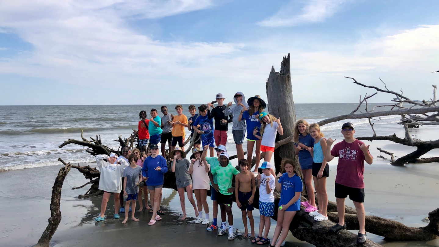 a group of people standing next to a body of water