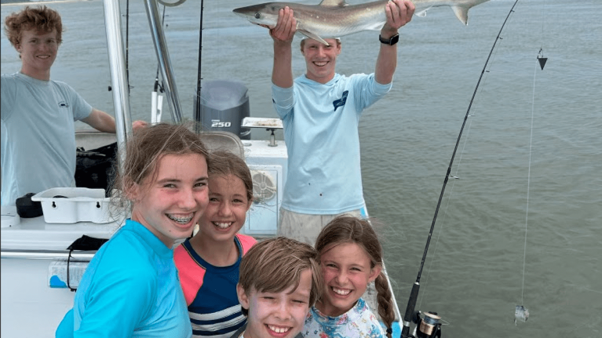 a group of young children standing on a boat