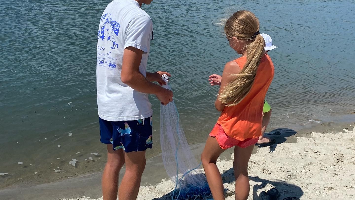 a group of people standing next to a body of water