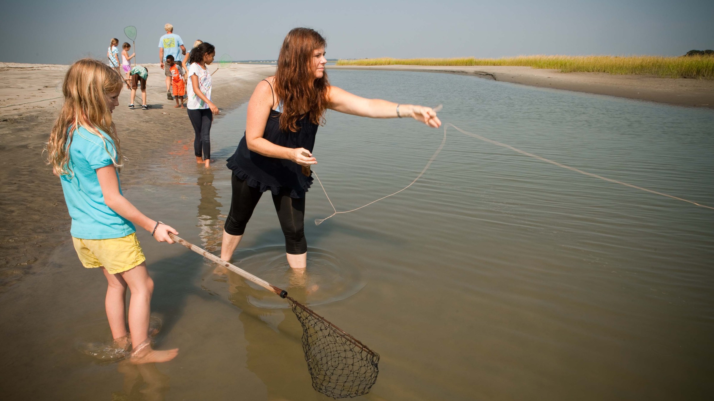 a woman holding a baby in a body of water
