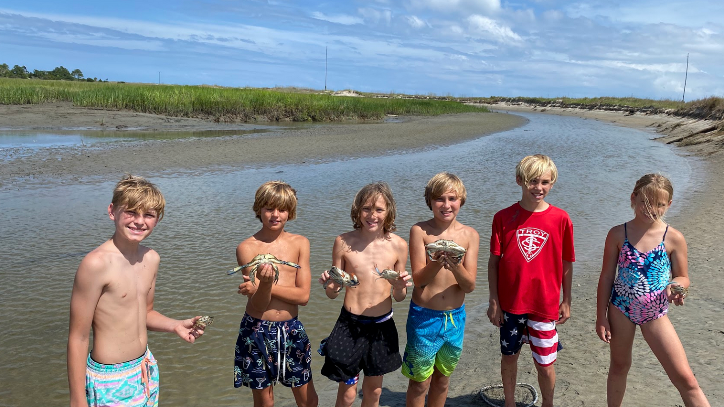 a group of young men standing next to a body of water