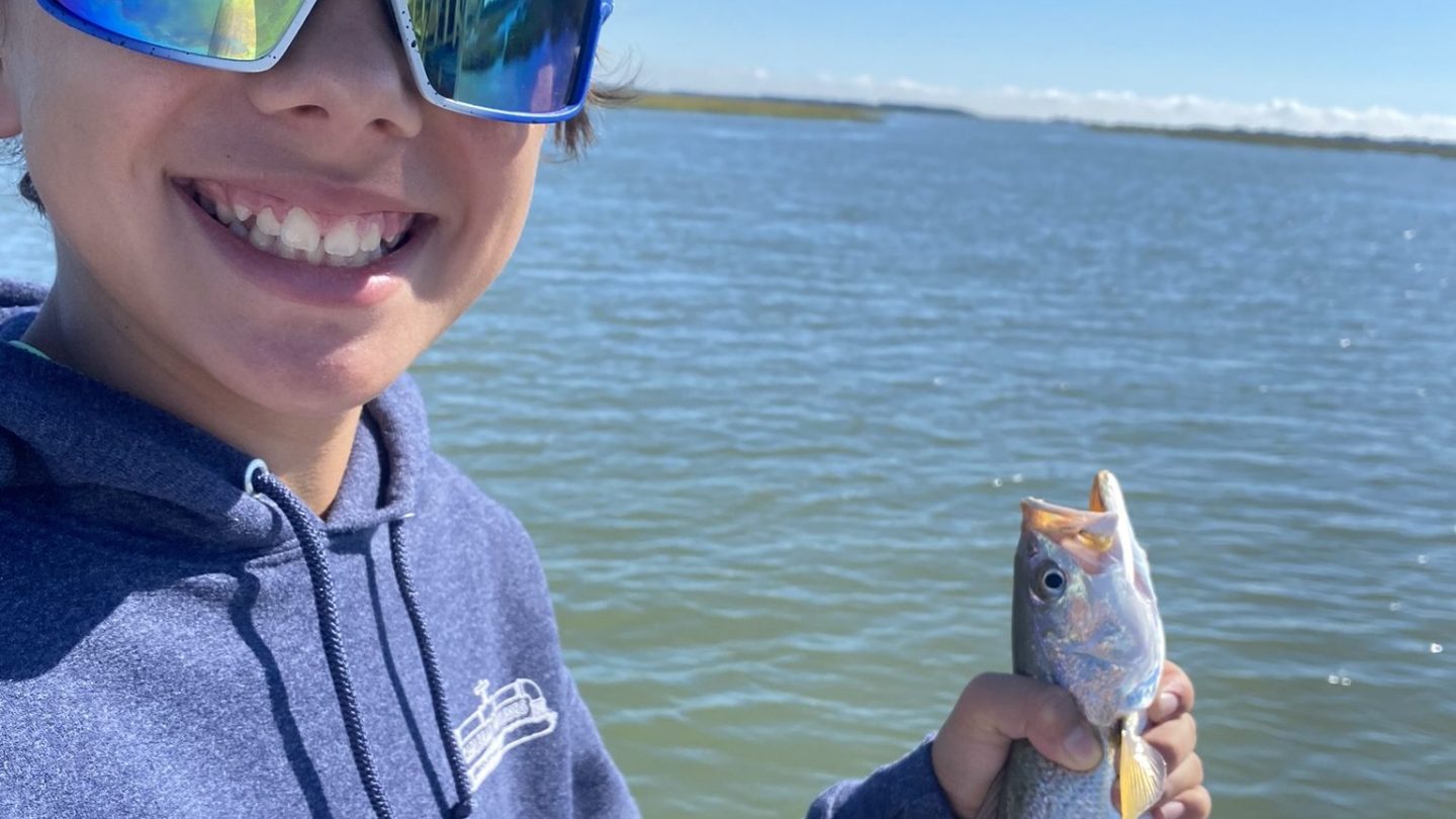 a person holding a fish in the water
