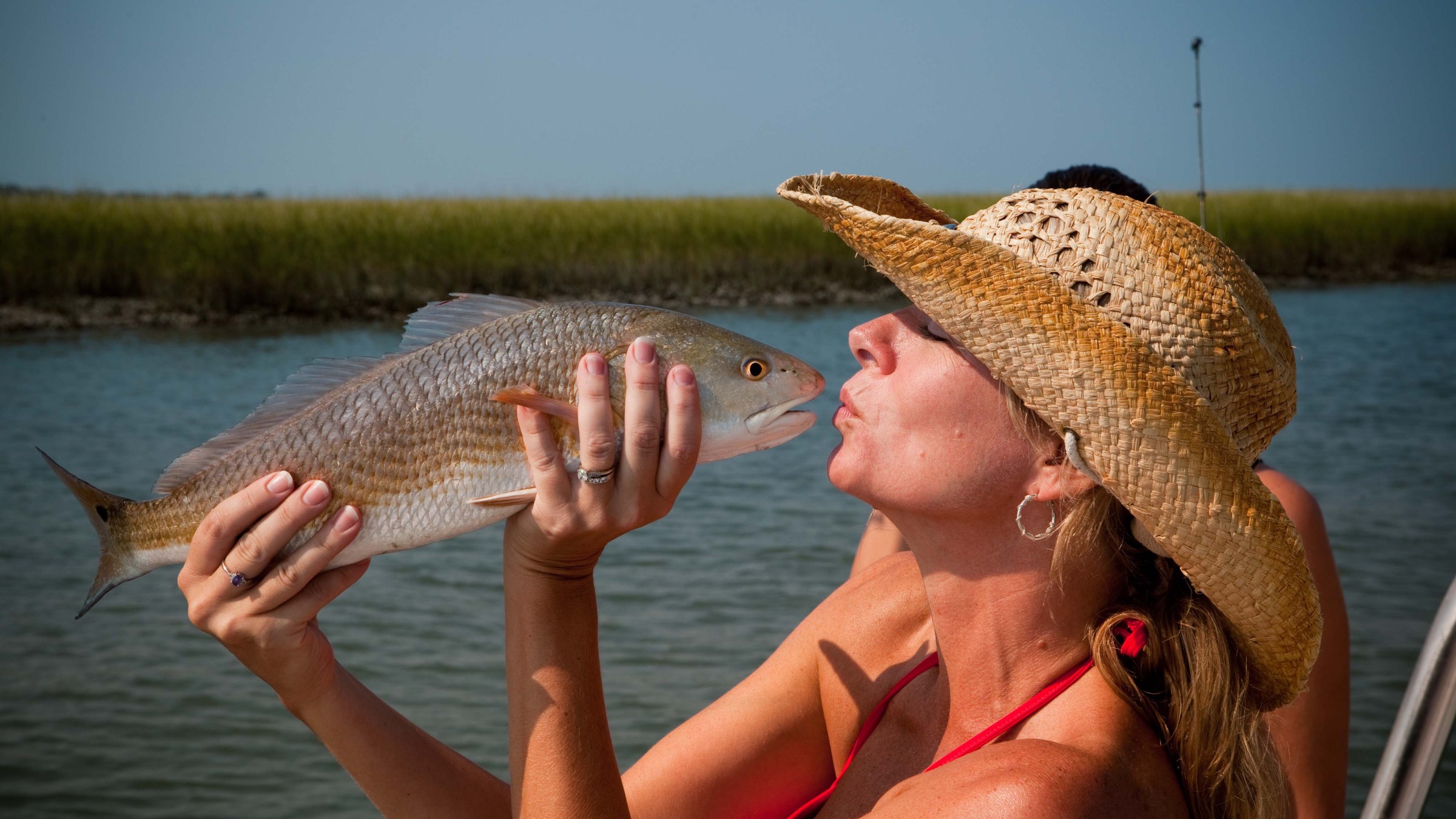 a person holding a fish swimming under water