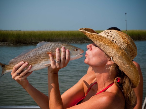a person holding a fish swimming under water