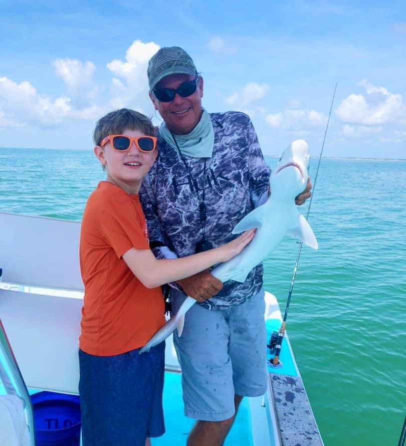 a man and a woman standing next to a body of water