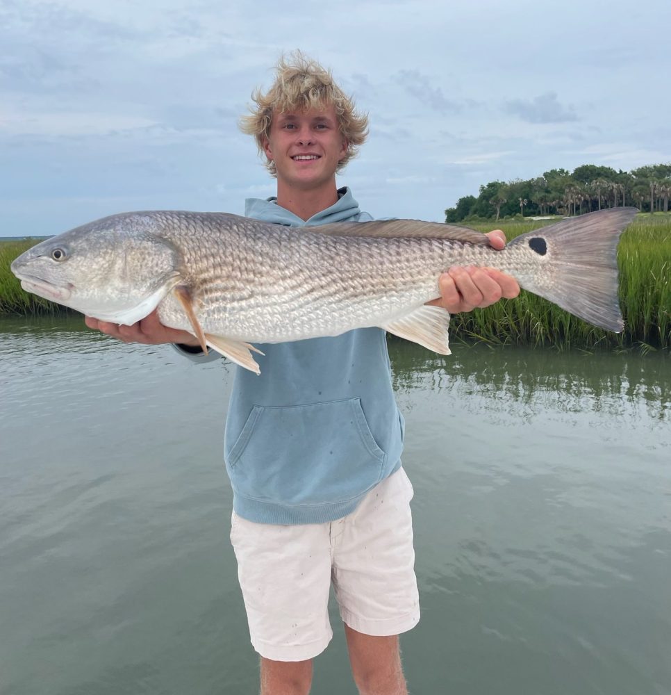 a young man holding a fish in the water